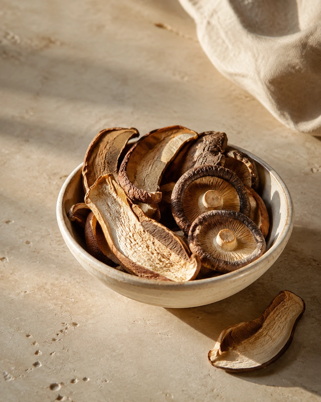 Dried shiitake mushrooms and porcini slices in a ceramic bowl